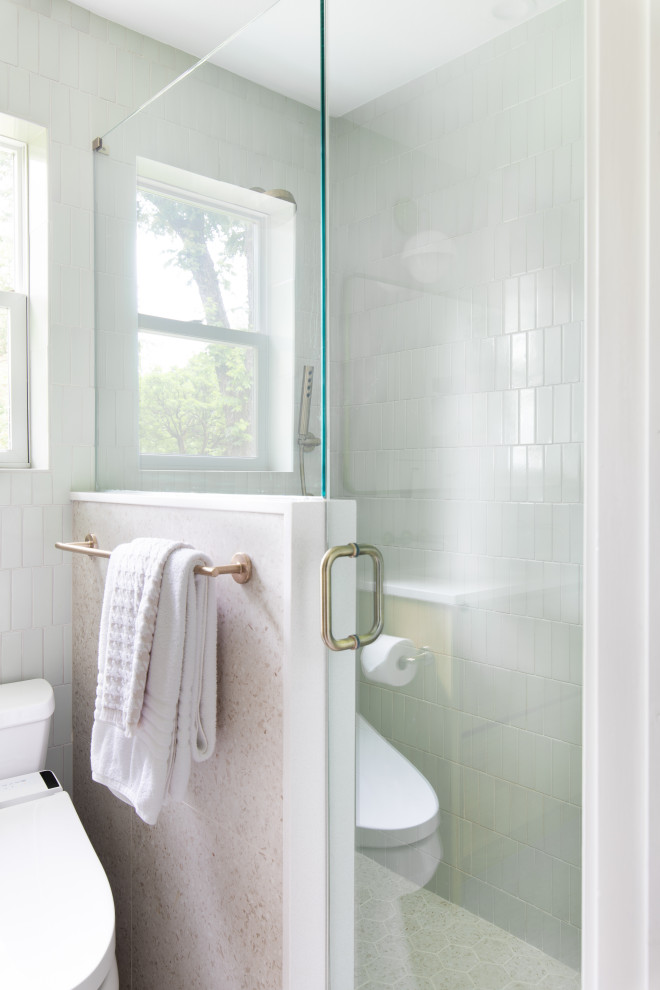 Inredning av ett klassiskt mellanstort vit vitt badrum med dusch, med släta luckor, skåp i ljust trä, en dusch i en alkov, en toalettstol med hel cisternkåpa, grön kakel, porslinskakel, vita väggar, ett undermonterad handfat, bänkskiva i kvarts, beiget golv och dusch med gångjärnsdörr