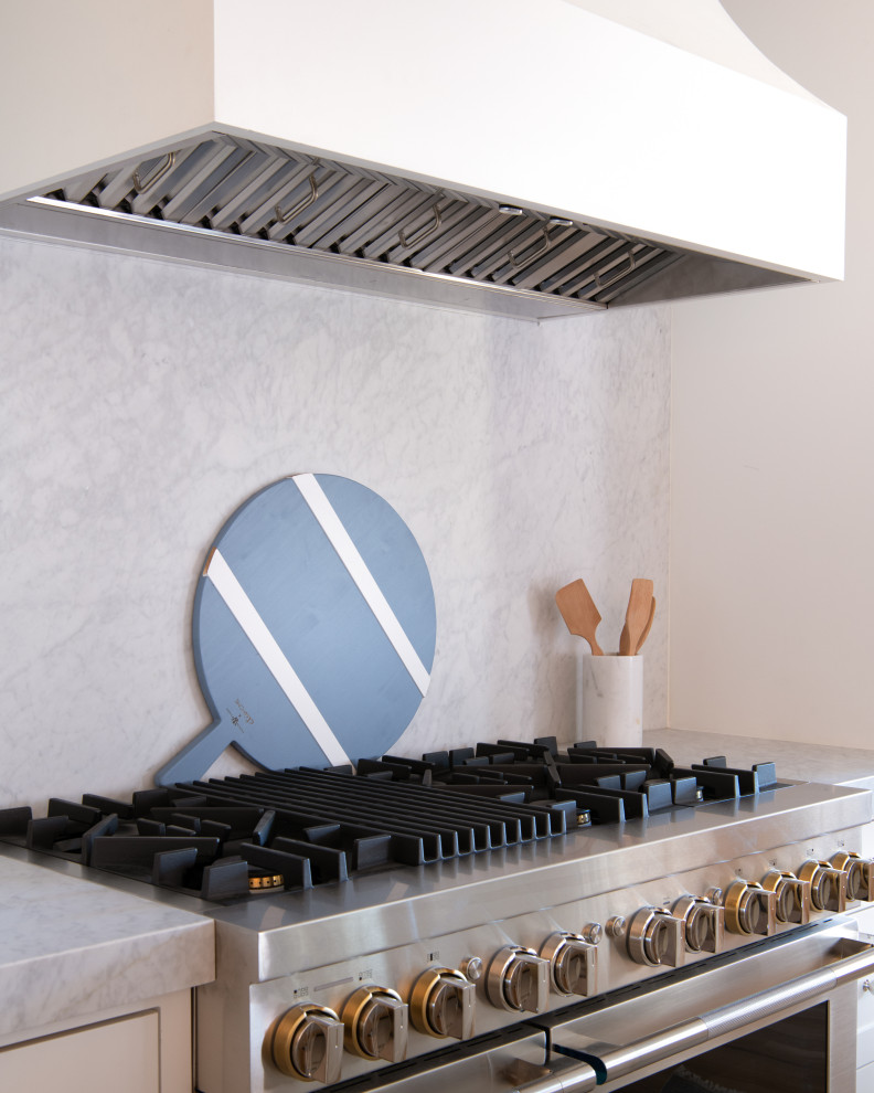 Inspiration for a large transitional l-shaped light wood floor, brown floor and exposed beam open concept kitchen remodel in Dallas with an undermount sink, shaker cabinets, white cabinets, marble countertops, white backsplash, marble backsplash, paneled appliances, an island and white countertops