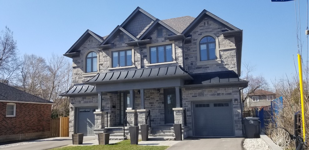 This is an example of a large transitional two-storey grey duplex exterior in Toronto with stone veneer, a gable roof and a shingle roof.