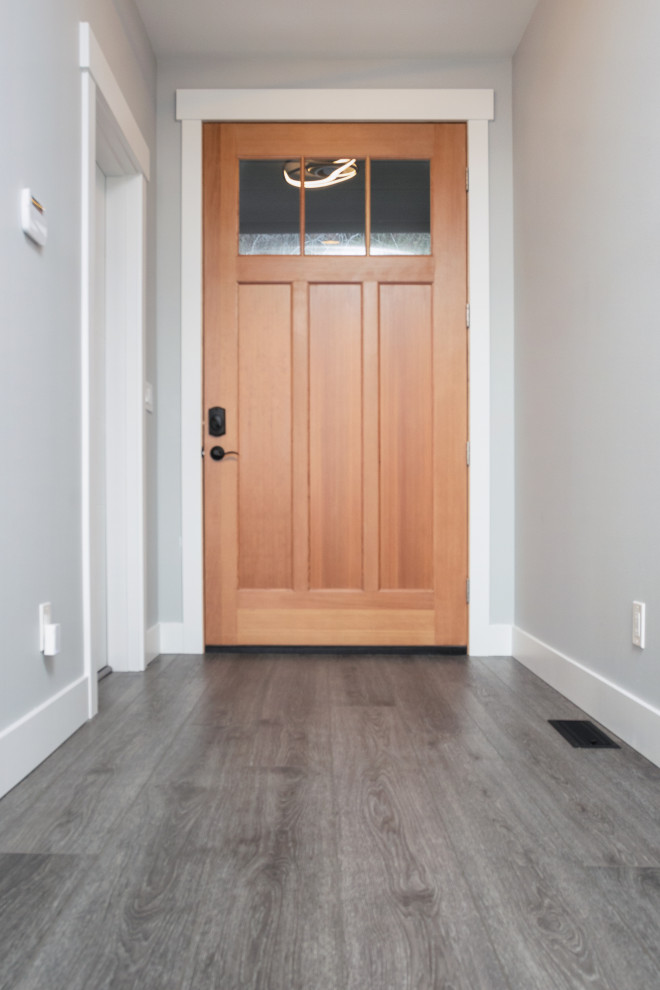 Große Moderne Haustür mit weißer Wandfarbe, Vinylboden, Einzeltür, hellbrauner Holzhaustür, grauem Boden und gewölbter Decke in Seattle