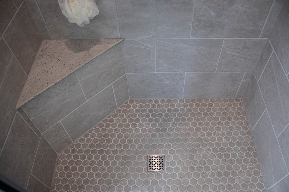 Inredning av ett klassiskt mellanstort grå grått en-suite badrum, med skåp i shakerstil, grå skåp, en dusch i en alkov, grå kakel, vinylgolv, bänkskiva i akrylsten, brunt golv och dusch med gångjärnsdörr