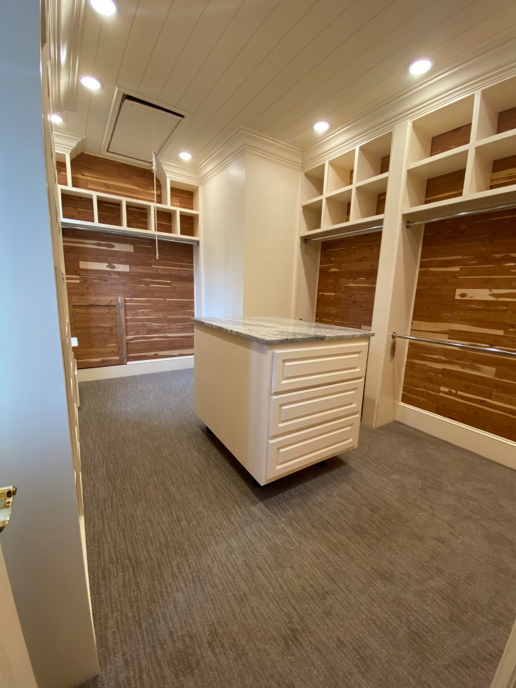 Photo of a large contemporary gender neutral walk-in wardrobe in Other with raised-panel cabinets, white cabinets, carpet, grey floors and a timber clad ceiling.