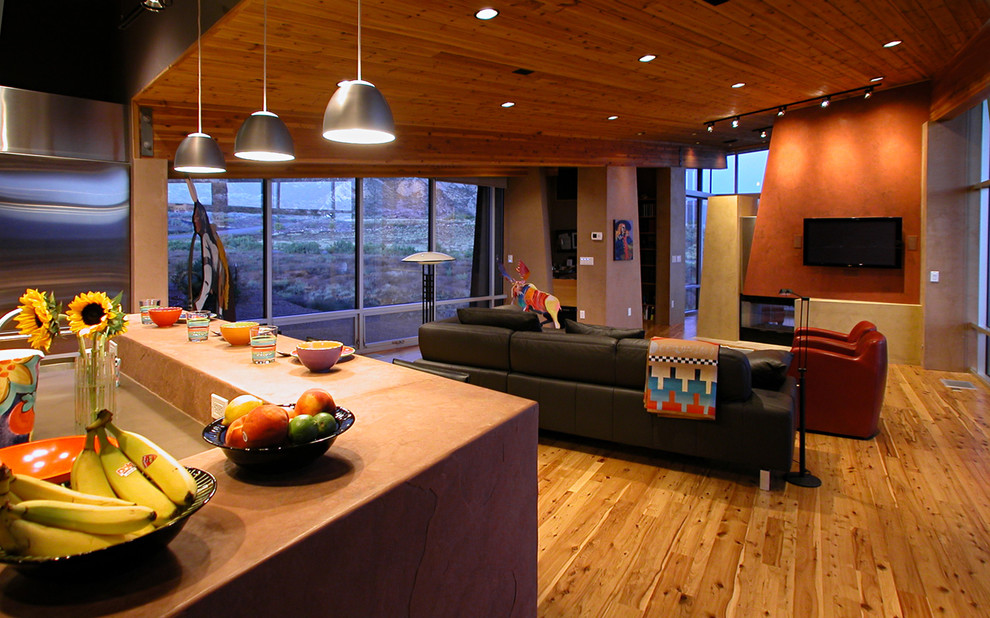 Photo of a contemporary open concept living room in Denver with orange walls, medium hardwood floors, a two-sided fireplace and a wall-mounted tv.
