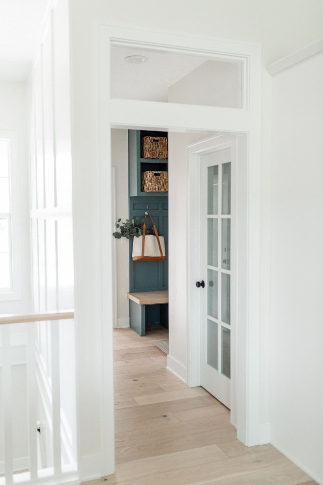 Design ideas for a mid-sized hallway in Los Angeles with white walls, light hardwood floors and white floor.