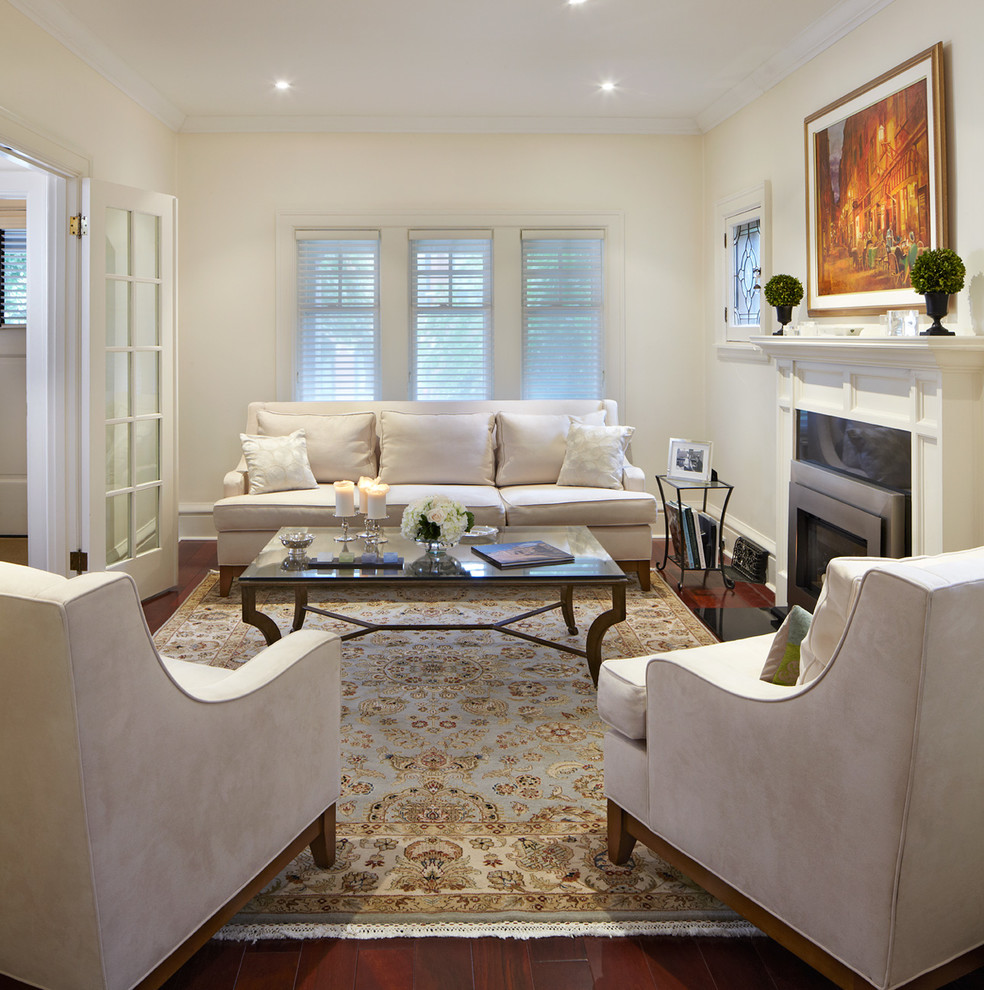 This is an example of a mid-sized transitional formal enclosed living room in Toronto with beige walls, dark hardwood floors, a standard fireplace, a stone fireplace surround, no tv and brown floor.