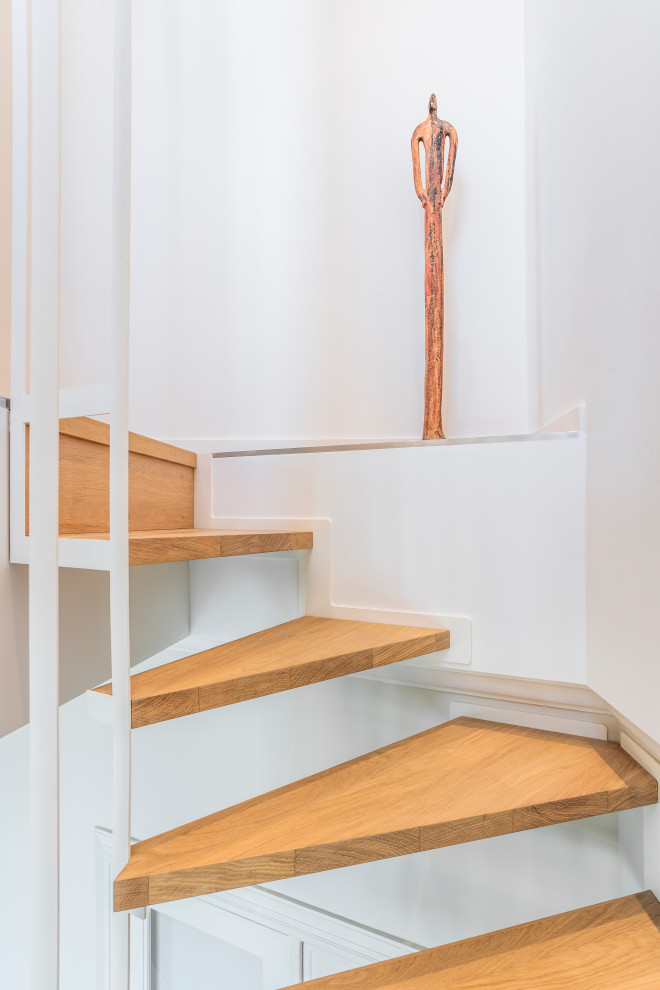 Cette photo montre un grand escalier sans contremarche flottant tendance avec des marches en bois et un garde-corps en métal.
