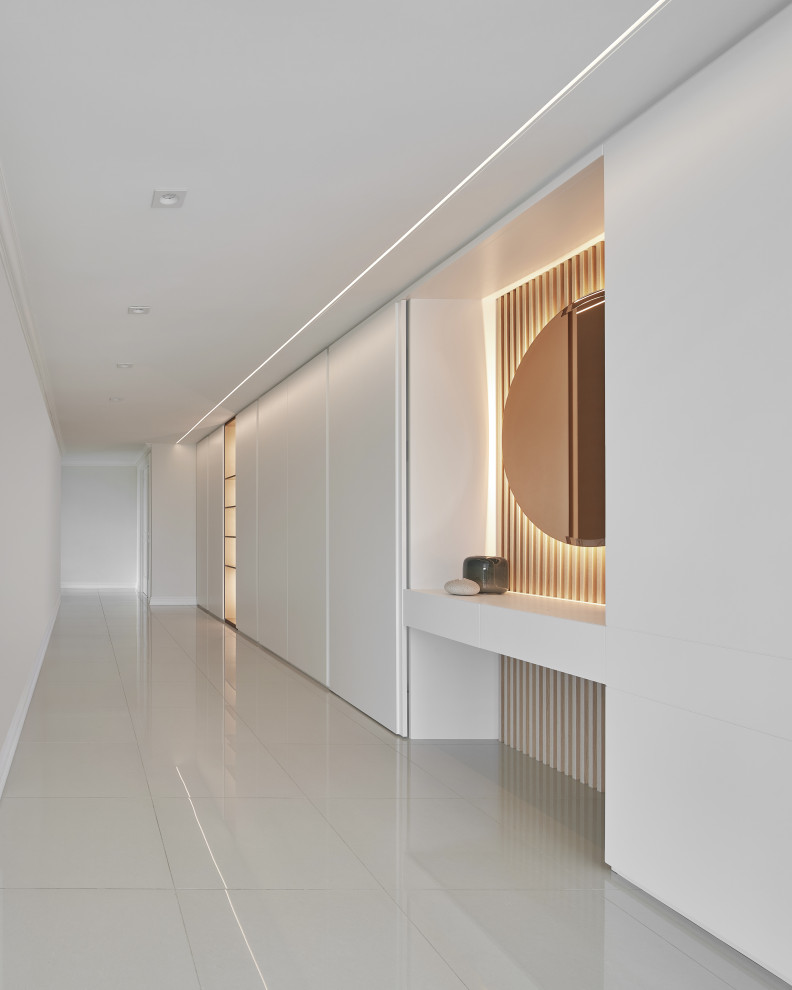 Cette photo montre un couloir moderne de taille moyenne avec un mur blanc, parquet clair et un sol gris.