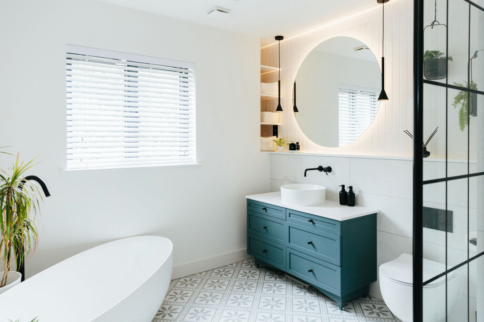 Design ideas for a mid-sized transitional kids bathroom in London with shaker cabinets, blue cabinets, a wall-mount toilet, white tile, mosaic tile floors, a drop-in sink, marble benchtops, blue floor, a hinged shower door, white benchtops, a single vanity, a built-in vanity and panelled walls.