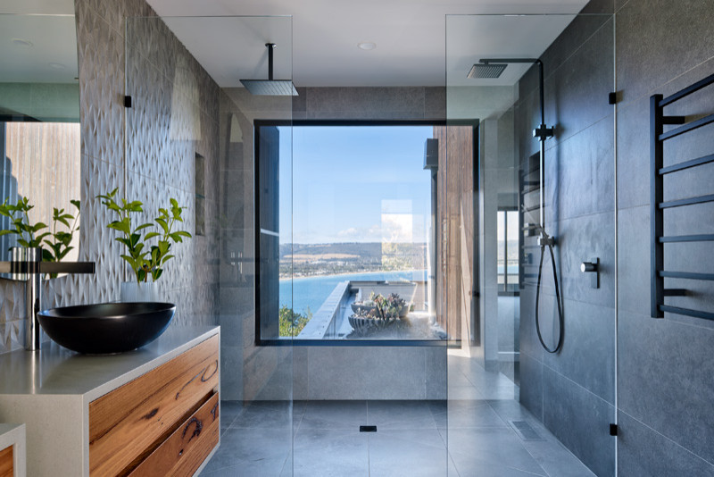 Photo of a large contemporary bathroom in Melbourne with flat-panel cabinets, medium wood cabinets, gray tile, ceramic tile, porcelain floors, solid surface benchtops, grey floor, grey benchtops, a double vanity and a floating vanity.