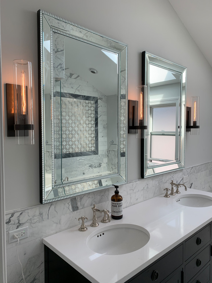 This is an example of a large classic ensuite bathroom in Chicago with freestanding cabinets, black cabinets, a built-in bath, a corner shower, a bidet, white tiles, marble tiles, grey walls, marble flooring, a submerged sink, engineered stone worktops, grey floors, a hinged door, white worktops, a shower bench, double sinks, a freestanding vanity unit and a vaulted ceiling.