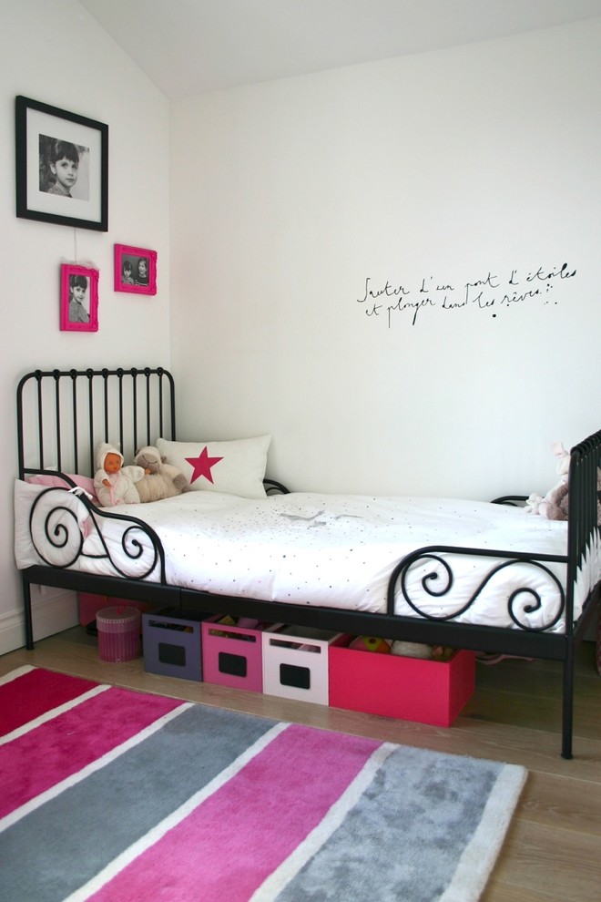 Design ideas for a transitional kids' room for girls in London with white walls and light hardwood floors.