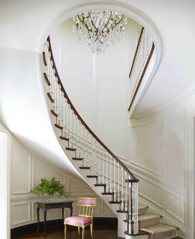 Идея дизайна: большая изогнутая деревянная лестница в классическом стиле с ступенями с ковровым покрытием и деревянными перилами