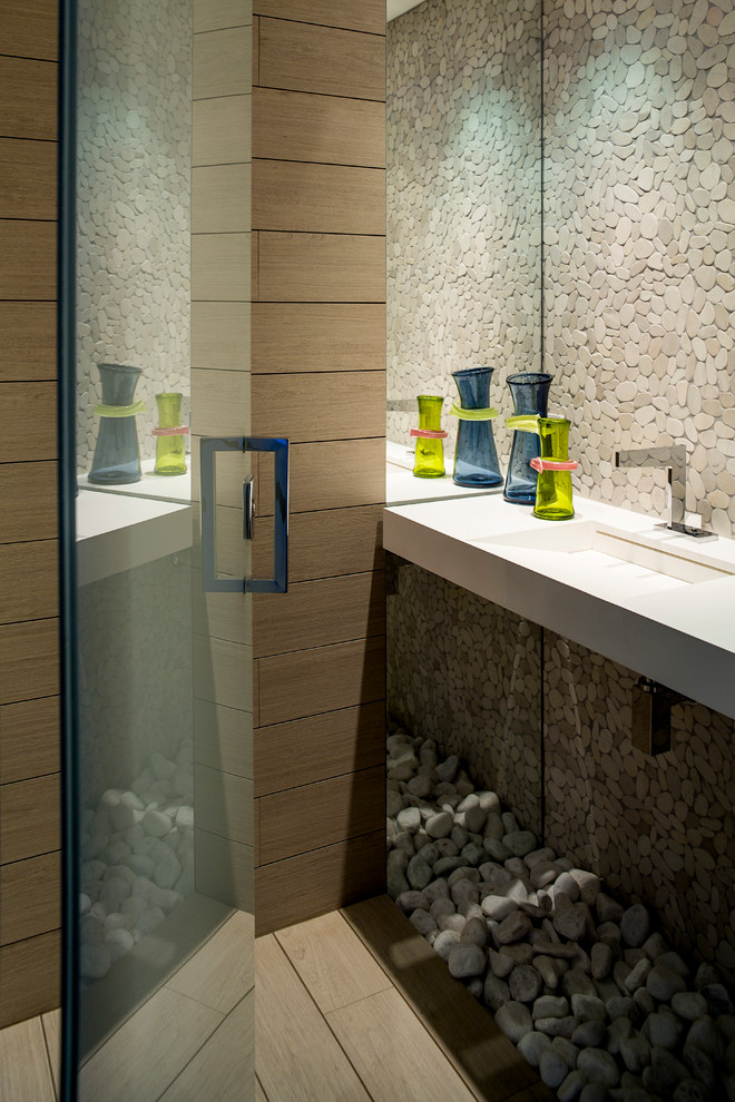 Photo of a contemporary powder room in Miami with an integrated sink, gray tile and pebble tile.