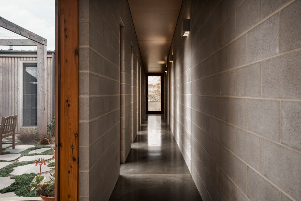 На фото: коридор среднего размера в стиле ретро с серыми стенами, бетонным полом, серым полом, потолком из вагонки и кирпичными стенами