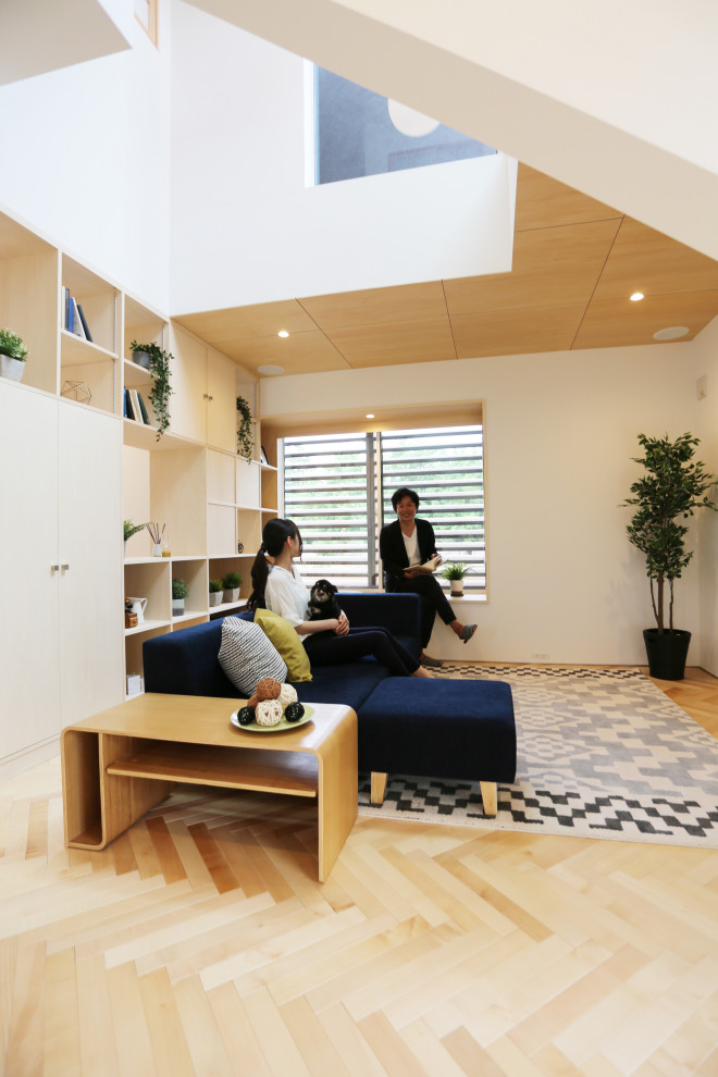 他の地域にある小さな北欧スタイルのおしゃれなLDK (ミュージックルーム、白い壁、淡色無垢フローリング、暖炉なし、壁掛け型テレビ、ベージュの床、塗装板張りの天井) の写真