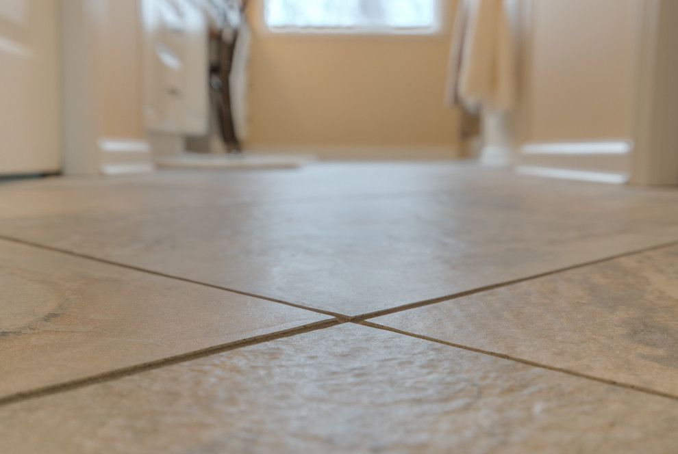 Home design - mid-sized transitional master multicolored tile ceramic tile home design idea with raised-panel cabinets, beige cabinets, a two-piece toilet, beige walls, an undermount sink and quartz countertops