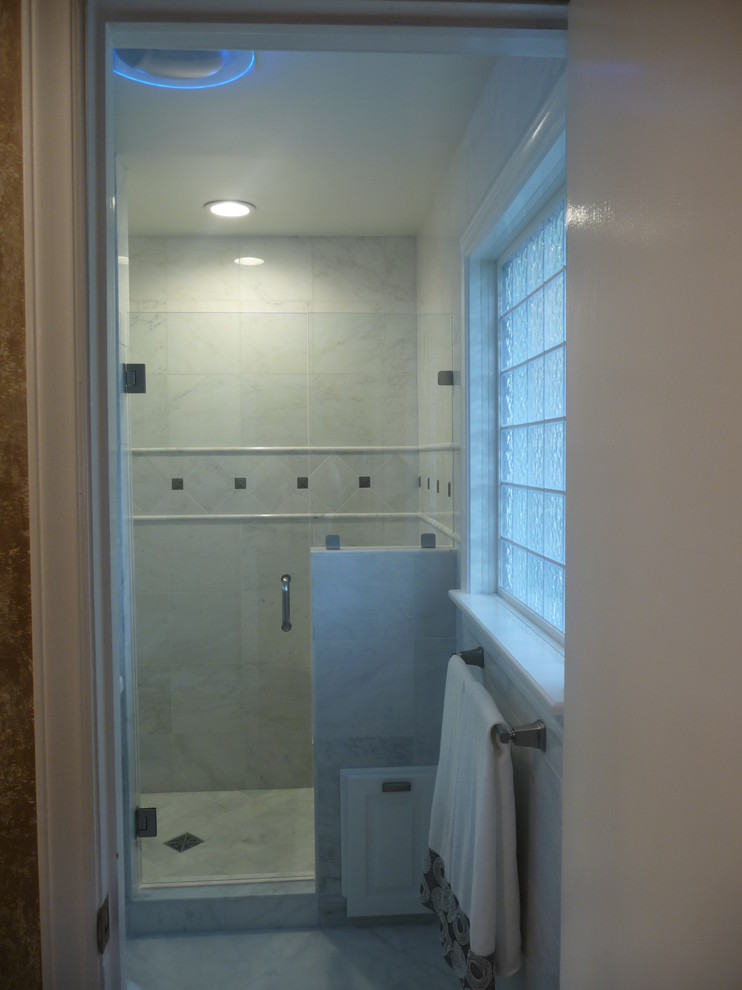 Design ideas for a small traditional master bathroom in Kansas City with glass-front cabinets, white cabinets, an alcove shower, a two-piece toilet, white tile, marble, white walls, marble floors, a wall-mount sink, white floor and a hinged shower door.