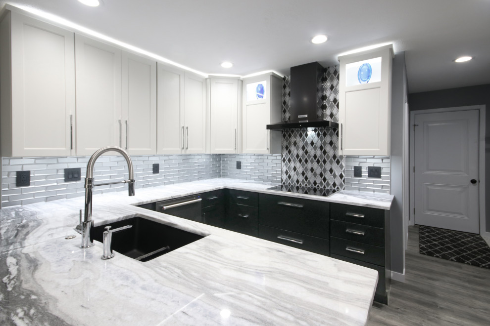 Design ideas for a contemporary kitchen/diner in Grand Rapids with a submerged sink, shaker cabinets, black appliances, a breakfast bar and grey floors.