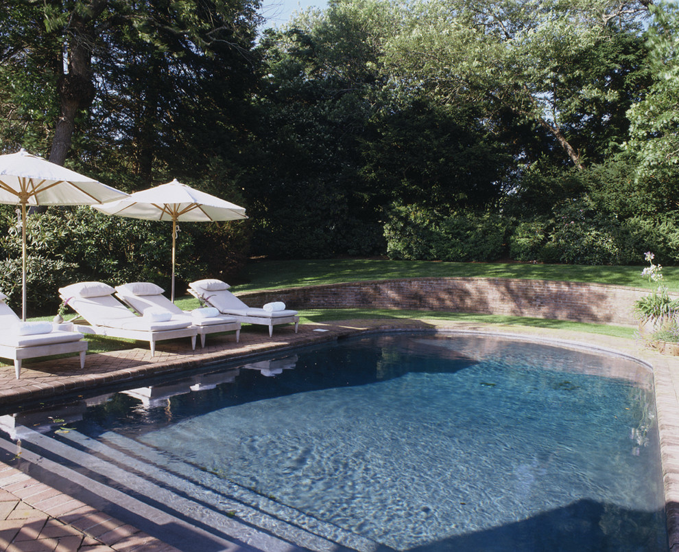 Inspiration for a contemporary custom-shaped pool in New York with brick pavers.