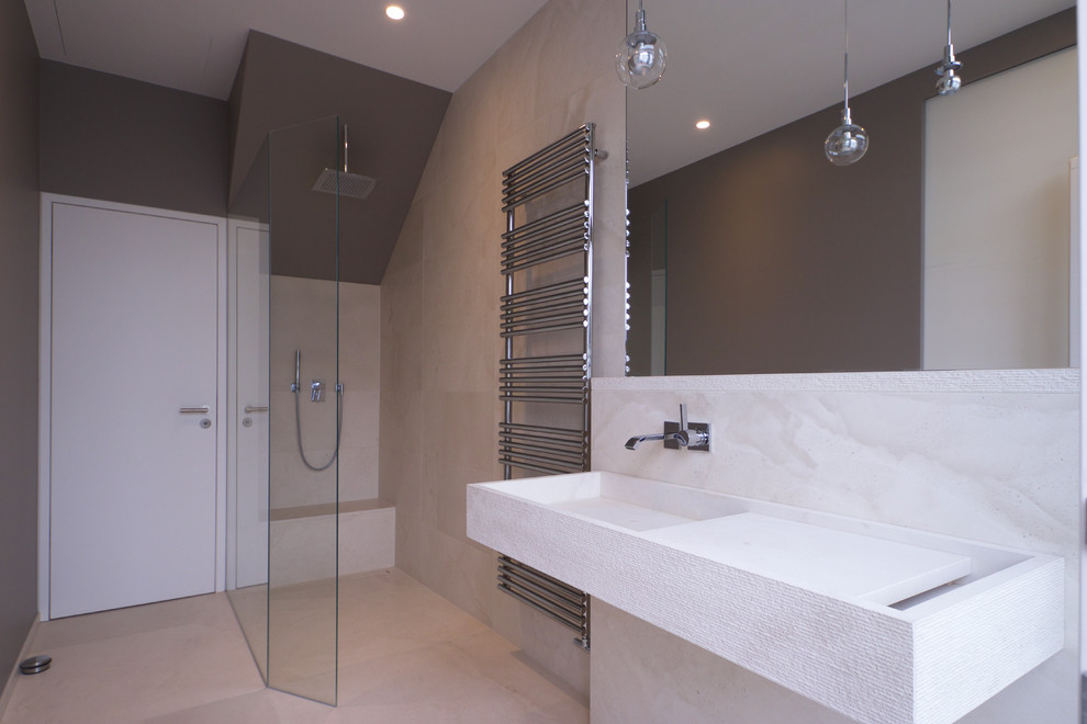 Immagine di una stanza da bagno con doccia contemporanea di medie dimensioni con doccia a filo pavimento, WC sospeso, piastrelle beige, pareti grigie, pavimento beige, doccia aperta e lavabo sospeso