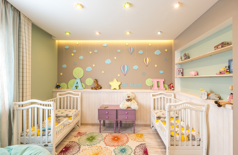 This is an example of a small transitional nursery for girls in Other with laminate floors, beige floor and multi-coloured walls.