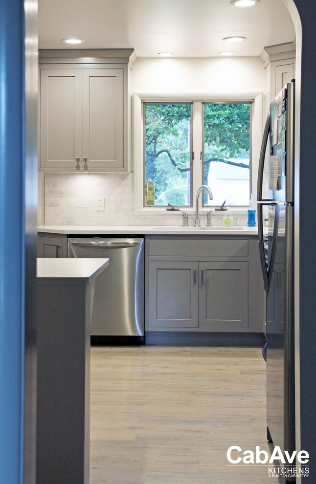 Small transitional l-shaped vinyl floor and brown floor enclosed kitchen photo with an undermount sink, recessed-panel cabinets, gray cabinets, quartz countertops, white backsplash, subway tile backsplash, stainless steel appliances and no island