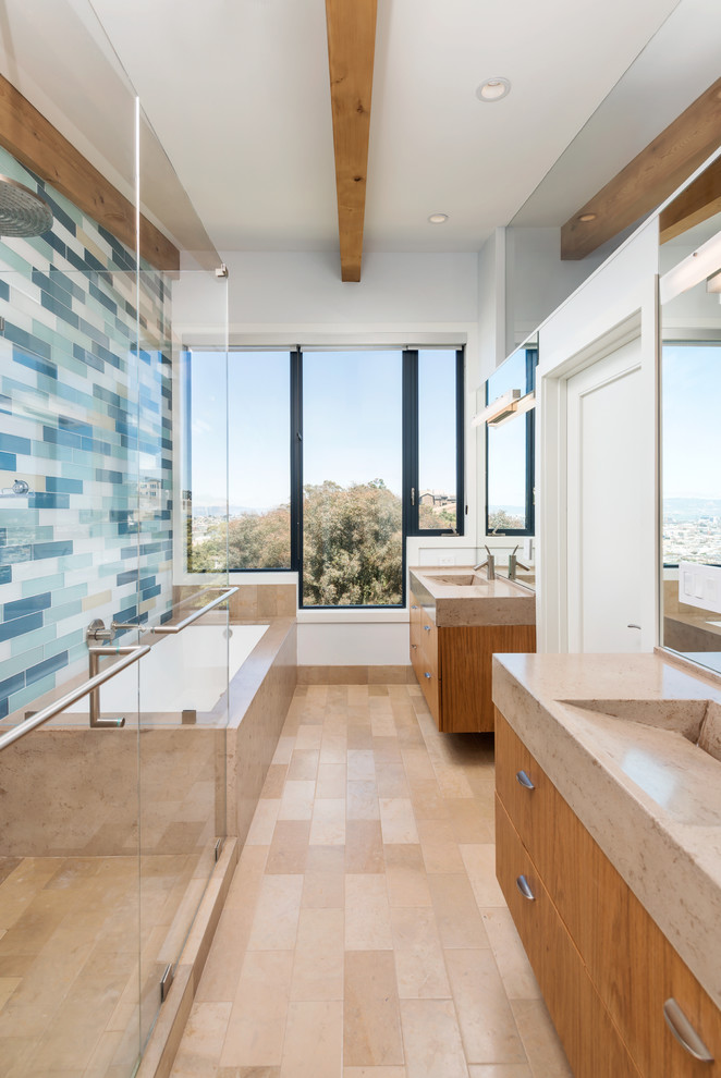 Mid-sized contemporary master bathroom in San Francisco with an integrated sink, flat-panel cabinets, medium wood cabinets, an undermount tub, multi-coloured tile, white walls, an alcove shower, glass tile and limestone benchtops.