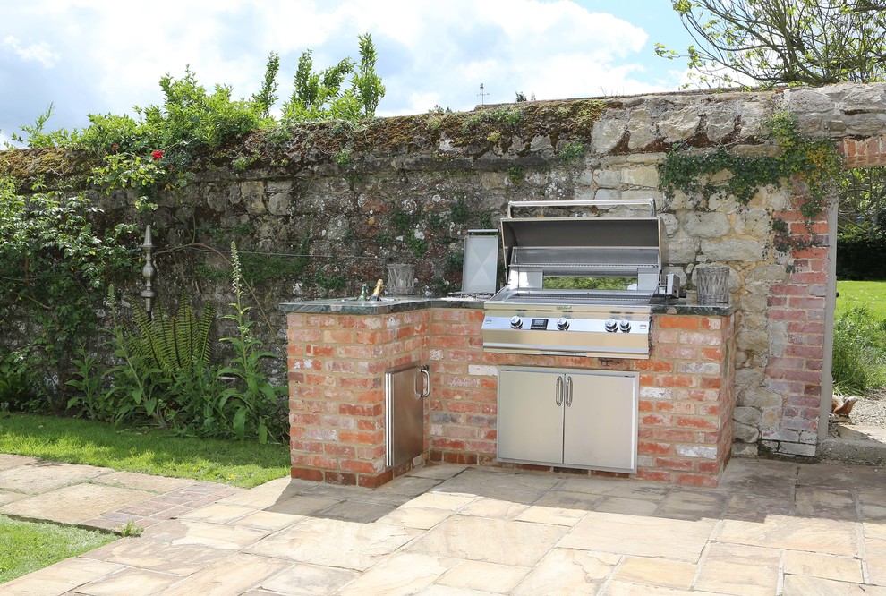 Small traditional courtyard patio in Kent with an outdoor kitchen, brick pavers and no cover.