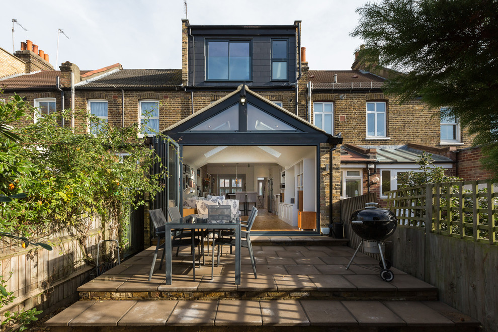 This is an example of a mid-sized traditional backyard patio in London with no cover.