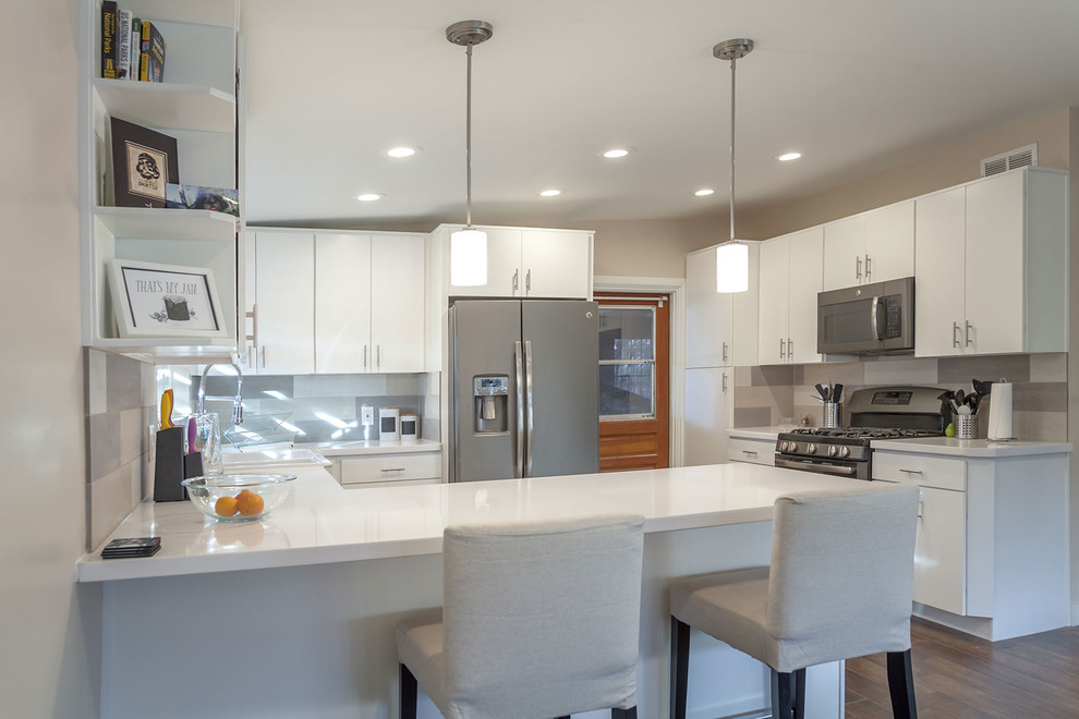 Open concept kitchen - transitional u-shaped porcelain tile open concept kitchen idea in Phoenix with a farmhouse sink, shaker cabinets, white cabinets, quartz countertops, multicolored backsplash, porcelain backsplash, stainless steel appliances and an island