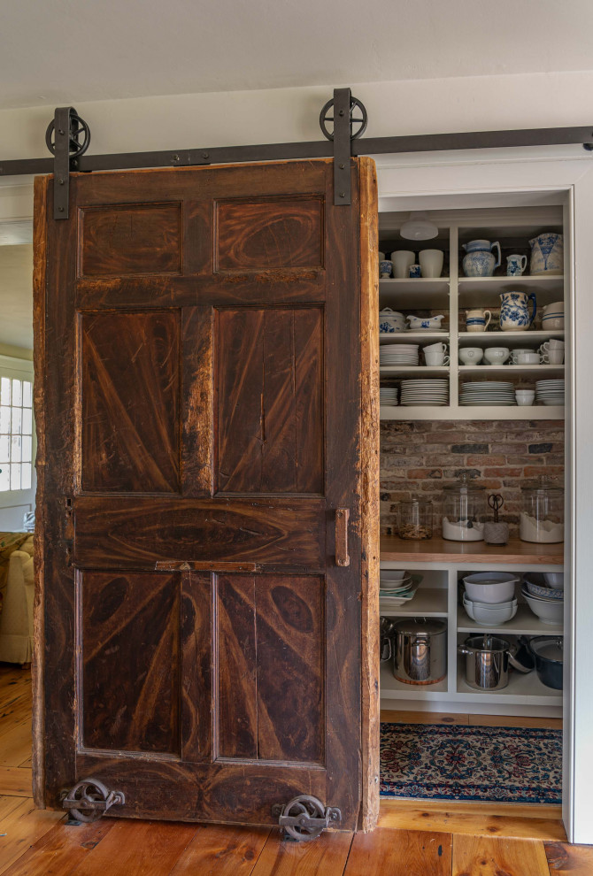 Inspiration for a small country l-shaped kitchen pantry in Boston with open cabinets, white cabinets, wood benchtops, brown splashback, light hardwood floors and no island.