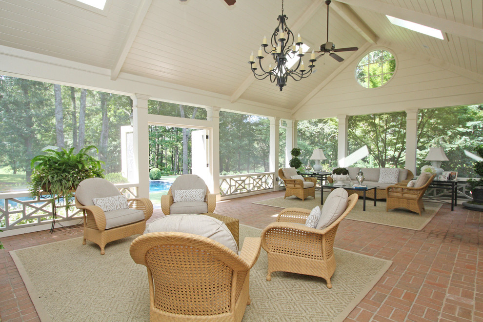 Large traditional backyard verandah in Atlanta with brick pavers and a roof extension.