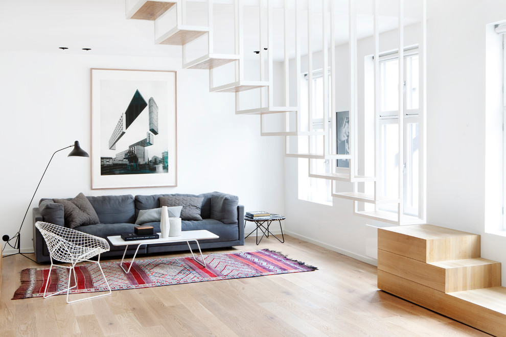 Design ideas for a scandinavian formal living room in London with white walls and light hardwood floors.