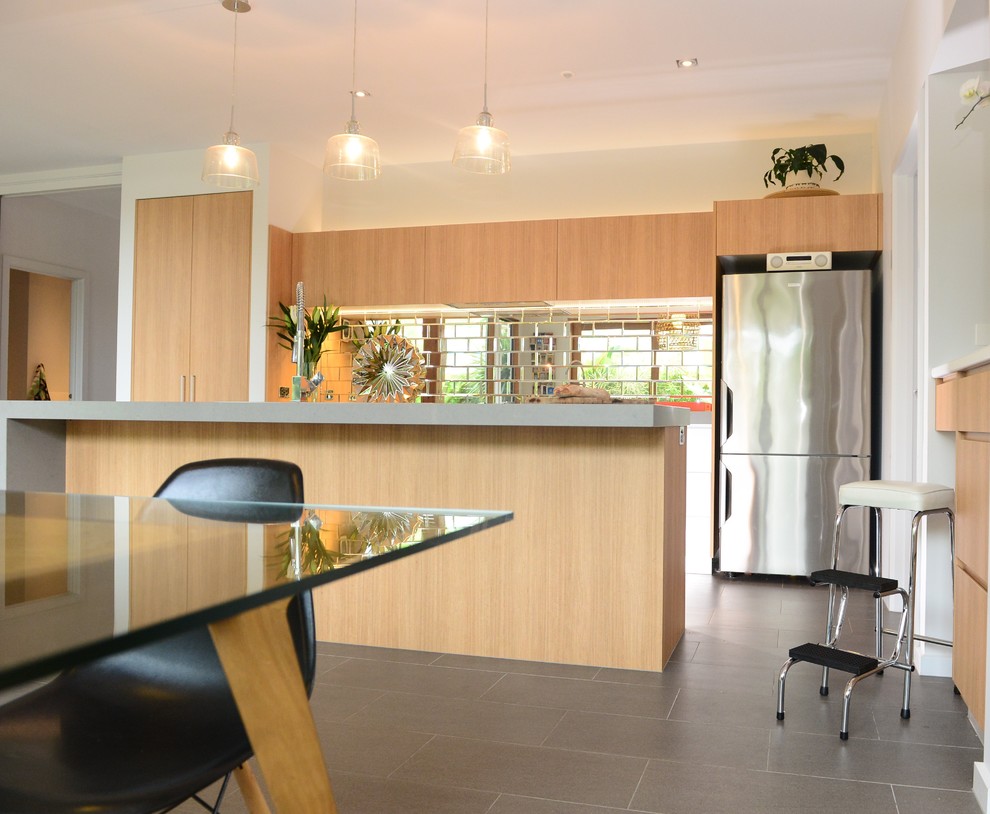 Photo of a mid-sized beach style kitchen in Geelong with a double-bowl sink, light wood cabinets, quartz benchtops, metallic splashback, glass tile splashback, stainless steel appliances, ceramic floors and with island.