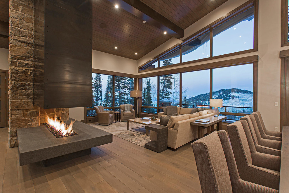 Design ideas for an expansive contemporary formal open concept living room in Salt Lake City with grey walls, medium hardwood floors, a two-sided fireplace, a metal fireplace surround and no tv.