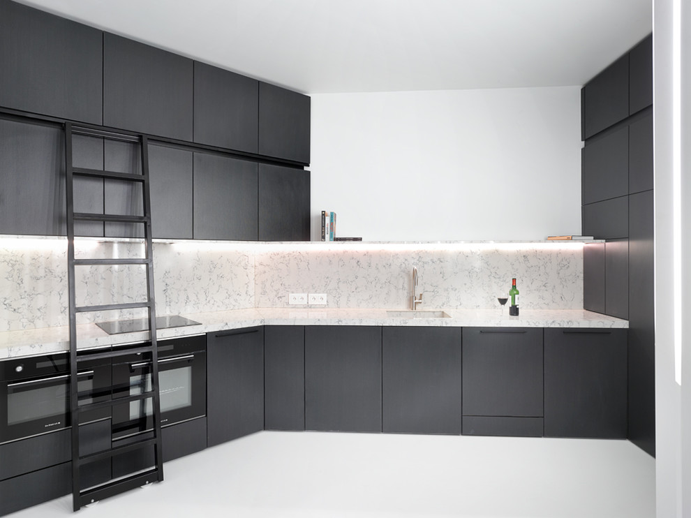 This is an example of a large contemporary l-shaped separate kitchen in Paris with an integrated sink, black cabinets, marble benchtops, white splashback, black appliances and no island.