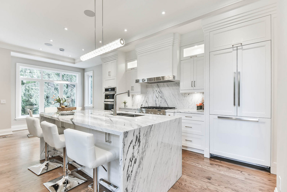 Transitional light wood floor and beige floor kitchen photo in Toronto with a double-bowl sink, recessed-panel cabinets, white cabinets, multicolored backsplash, stone slab backsplash, paneled appliances, an island and multicolored countertops