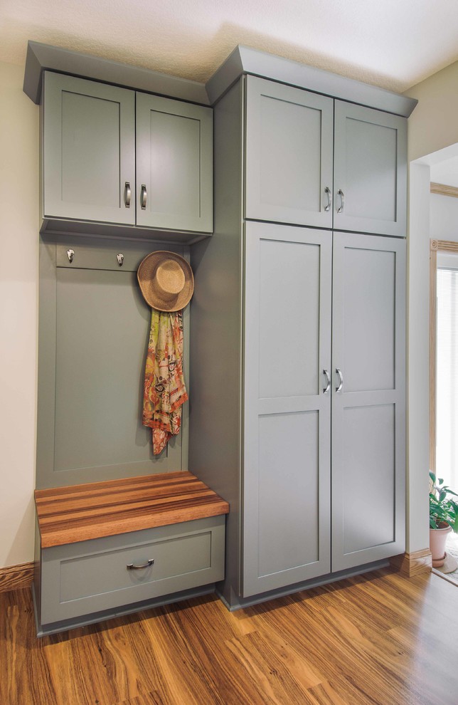 Example of a small transitional galley vinyl floor eat-in kitchen design with recessed-panel cabinets, white cabinets, gray backsplash and stainless steel appliances