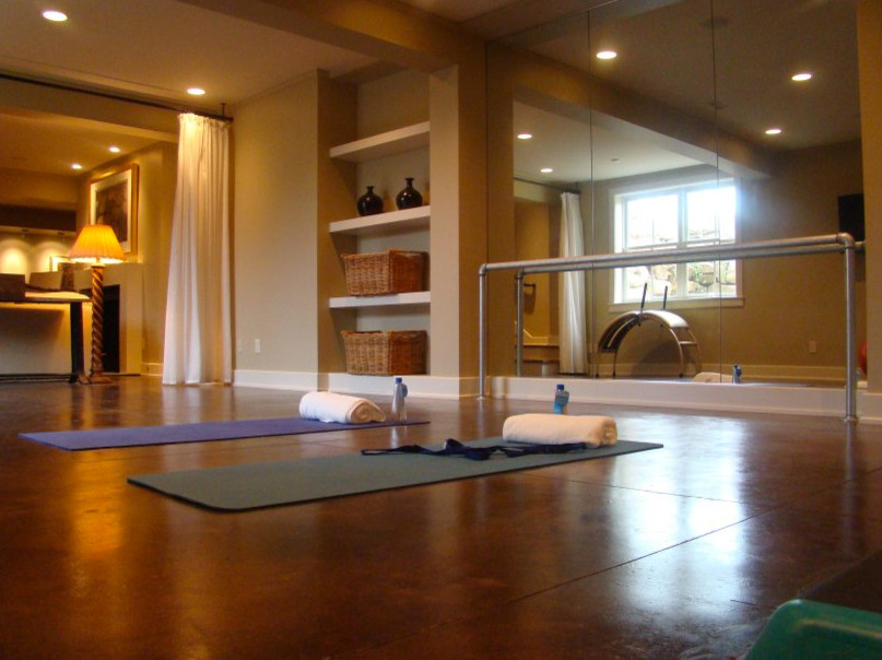 This is an example of a large traditional home yoga studio in Chicago with beige walls and concrete floors.