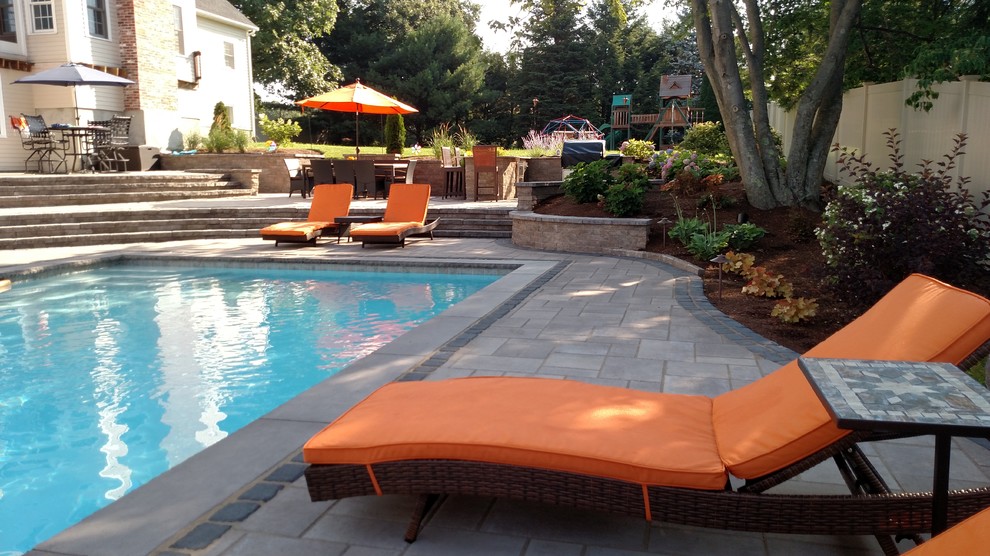This is an example of a mid-sized contemporary backyard rectangular lap pool in Boston with concrete pavers.