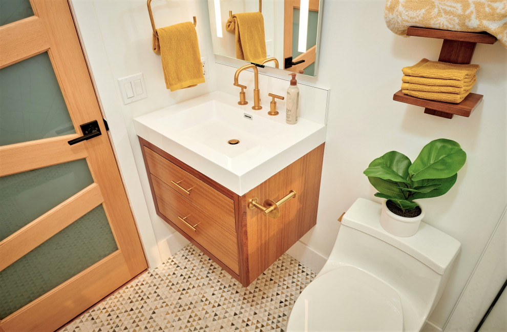 This is an example of a small tropical kids bathroom in Denver with flat-panel cabinets, medium wood cabinets, a two-piece toilet, white tile, porcelain tile, white walls, mosaic tile floors, an integrated sink, engineered quartz benchtops, white floor, a hinged shower door, white benchtops, a single vanity, a floating vanity and wallpaper.