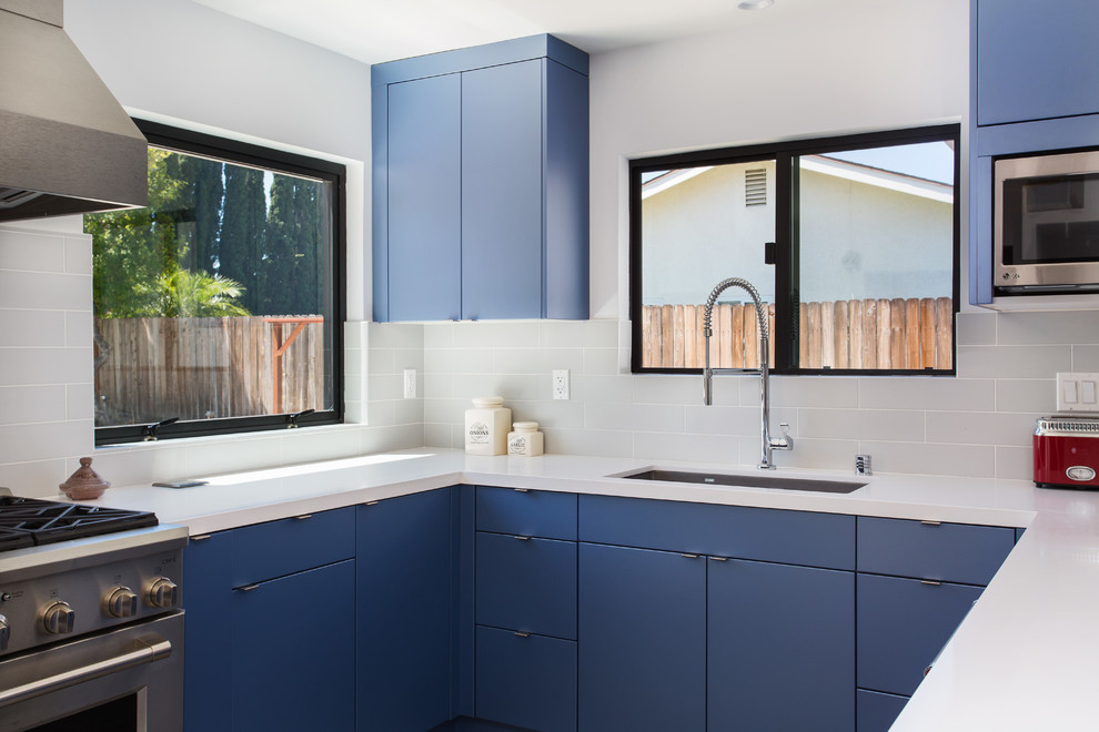 Inspiration for a small modern u-shaped eat-in kitchen in Los Angeles with an undermount sink, flat-panel cabinets, blue cabinets, quartz benchtops, grey splashback, subway tile splashback, stainless steel appliances, porcelain floors, no island, grey floor and white benchtop.