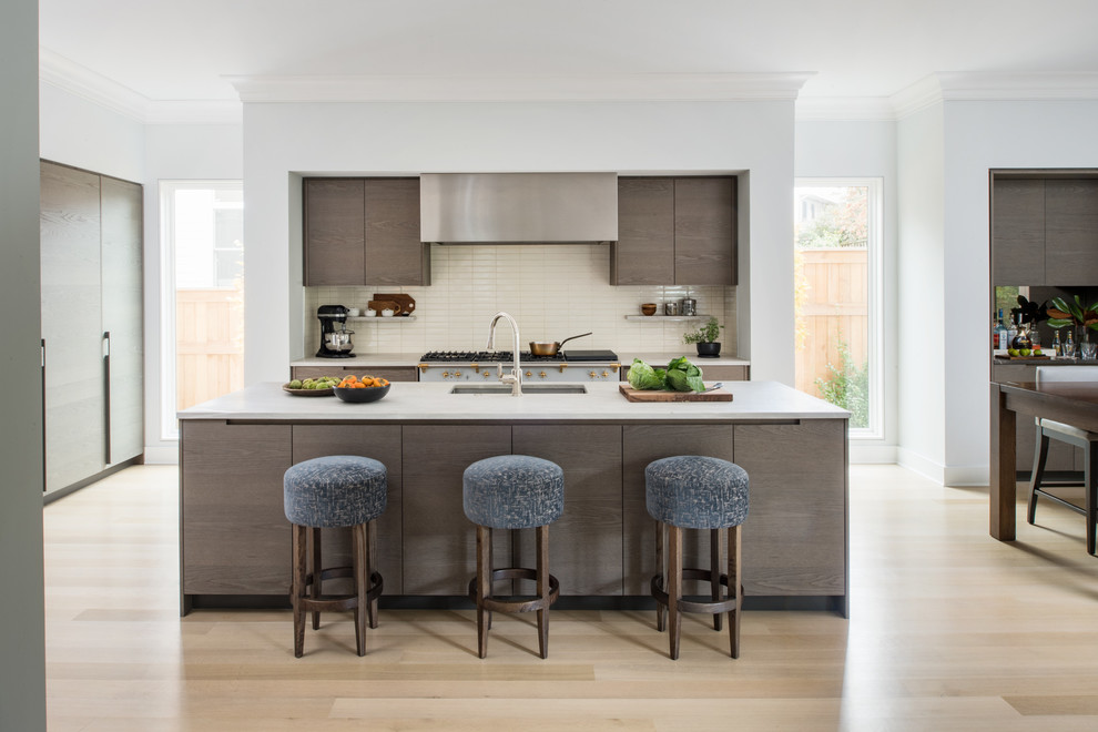 This is an example of a mid-sized contemporary single-wall eat-in kitchen in DC Metro with an undermount sink, flat-panel cabinets, dark wood cabinets, beige splashback, light hardwood floors, with island, beige floor, white benchtop, solid surface benchtops, ceramic splashback and stainless steel appliances.