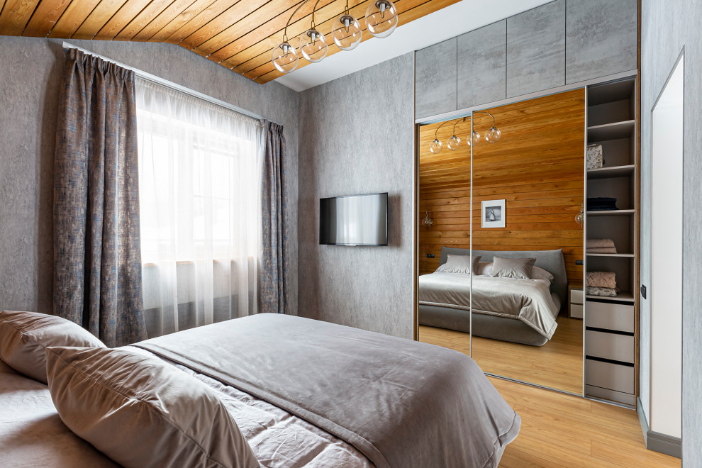 Esempio di una piccola camera da letto contemporanea con pareti grigie, pavimento in laminato, pavimento giallo, soffitto in perlinato e pareti in legno