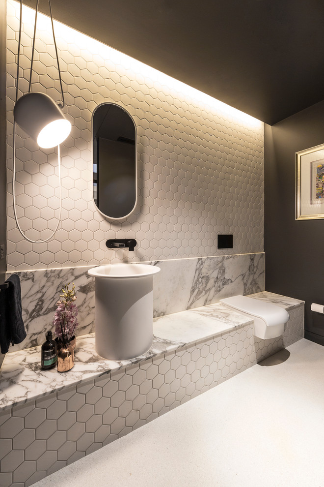 Photo of a contemporary powder room in Melbourne with a wall-mount toilet, white walls, a vessel sink, white floor and white benchtops.