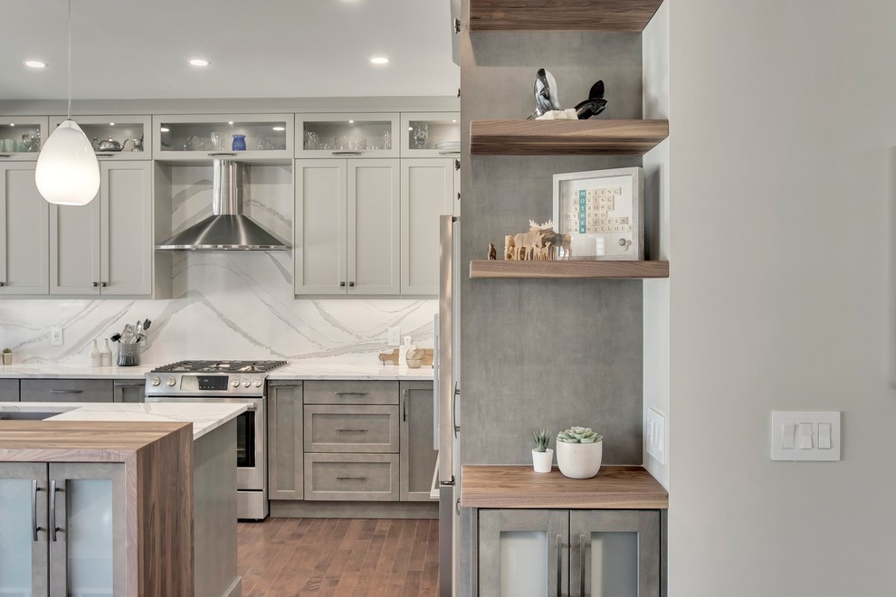 Inspiration for a large transitional u-shaped dark wood floor and brown floor eat-in kitchen remodel in Calgary with an undermount sink, recessed-panel cabinets, gray cabinets, quartzite countertops, white backsplash, stone slab backsplash, stainless steel appliances, an island and white countertops