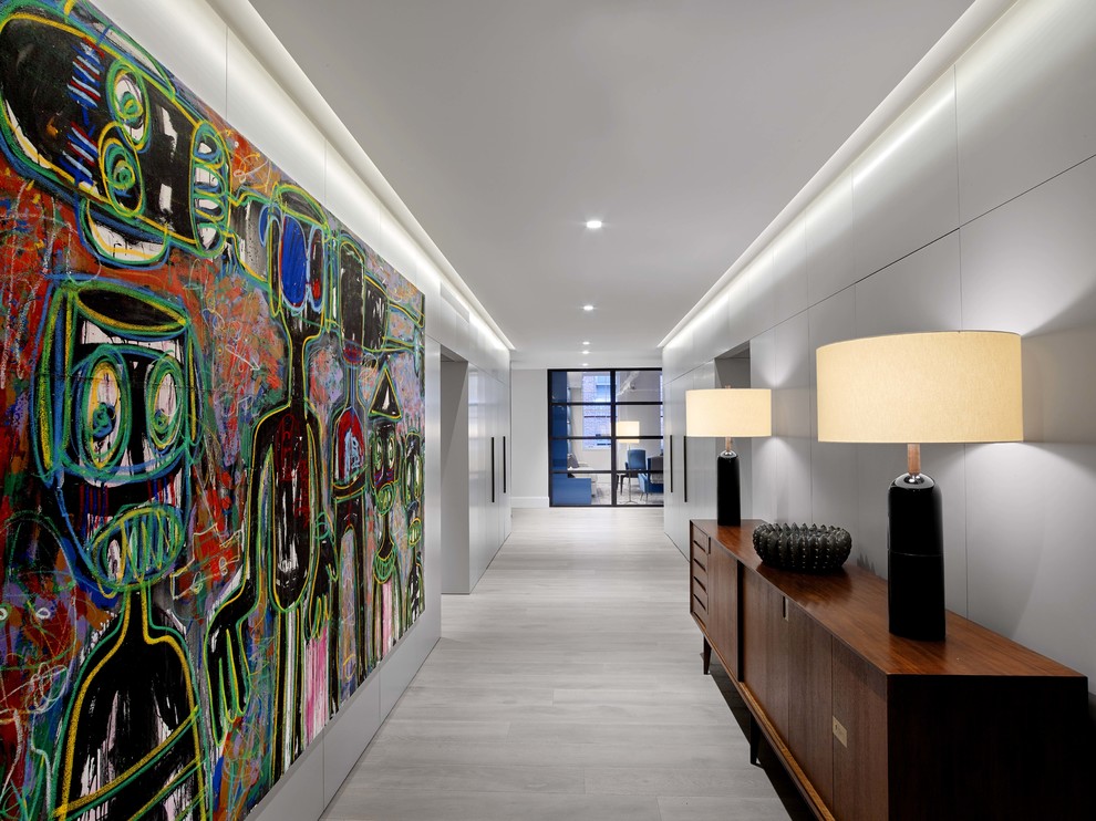 Photo of a large contemporary hallway in New York with grey walls, light hardwood floors and grey floor.