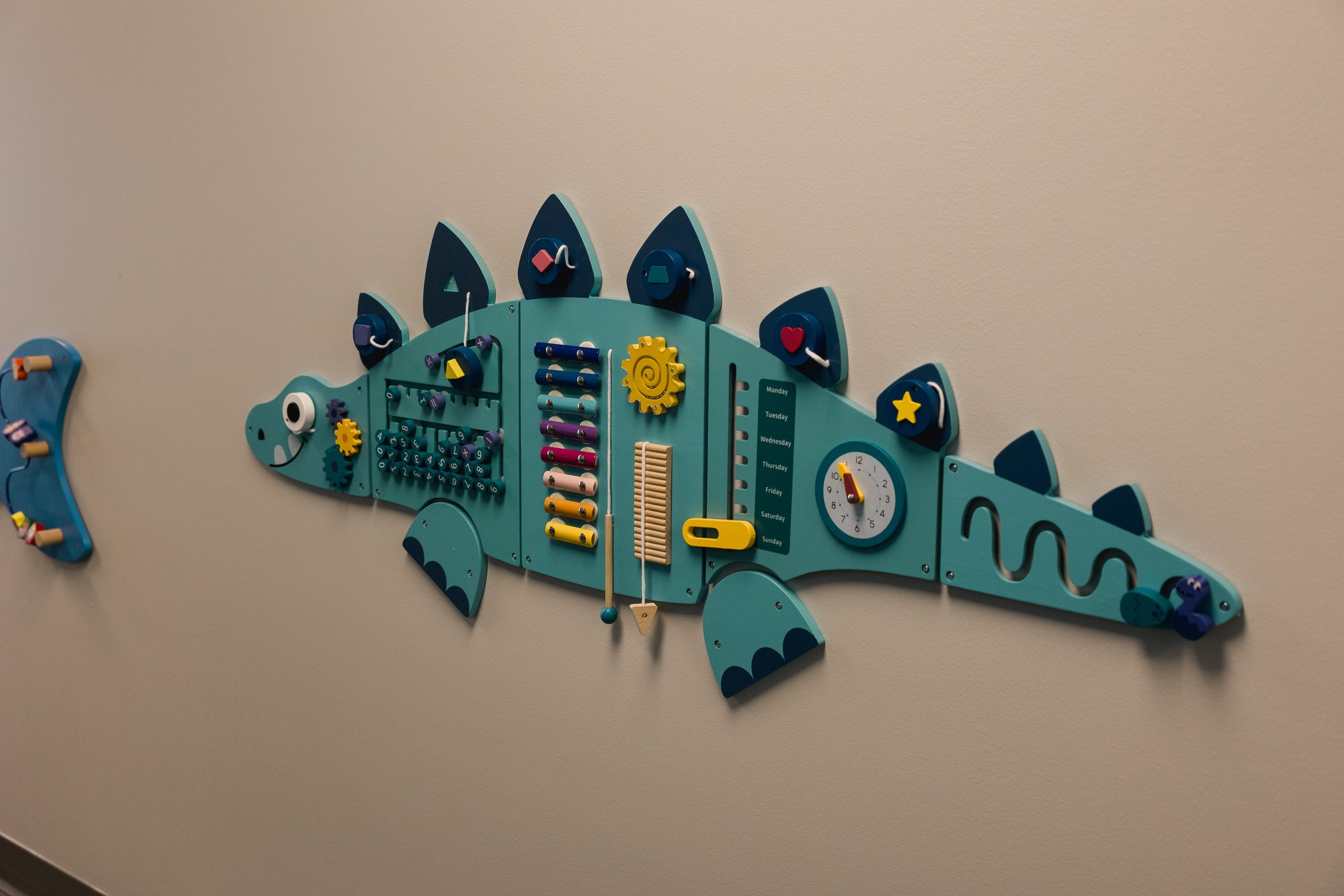 Dinosaur activity wall panel in hallway, Galliant Autism Center Omaha