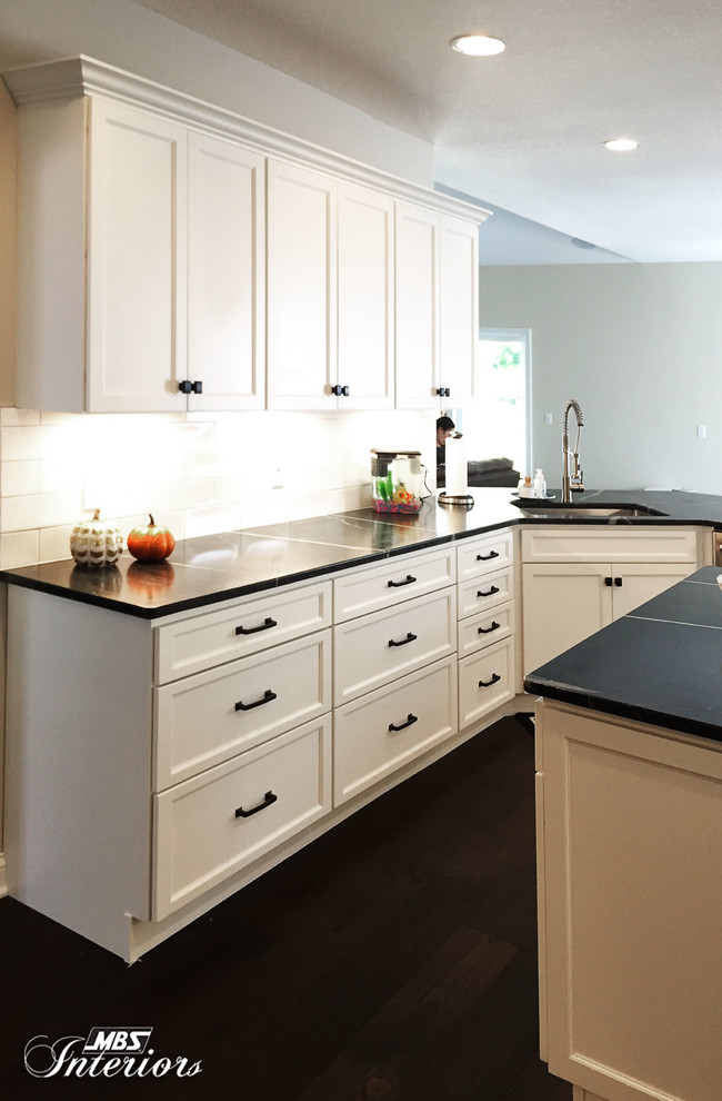 Eat-in kitchen - mid-sized transitional u-shaped dark wood floor and brown floor eat-in kitchen idea with an undermount sink, recessed-panel cabinets, white cabinets, soapstone countertops, white backsplash, subway tile backsplash, stainless steel appliances and an island