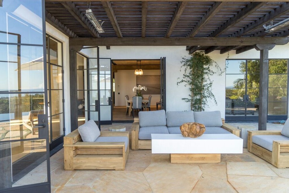 Design ideas for a contemporary patio in Santa Barbara with natural stone pavers and a pergola.